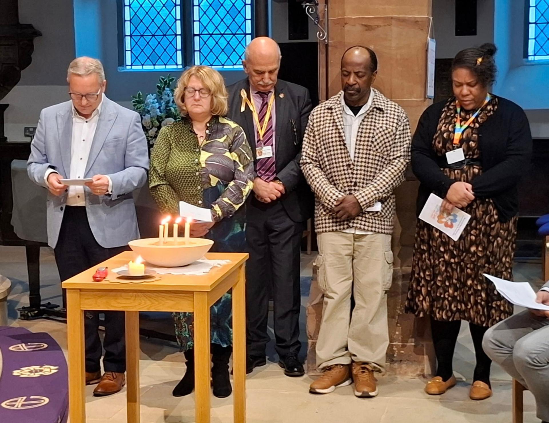 Chaplains gathered around candles in prayer