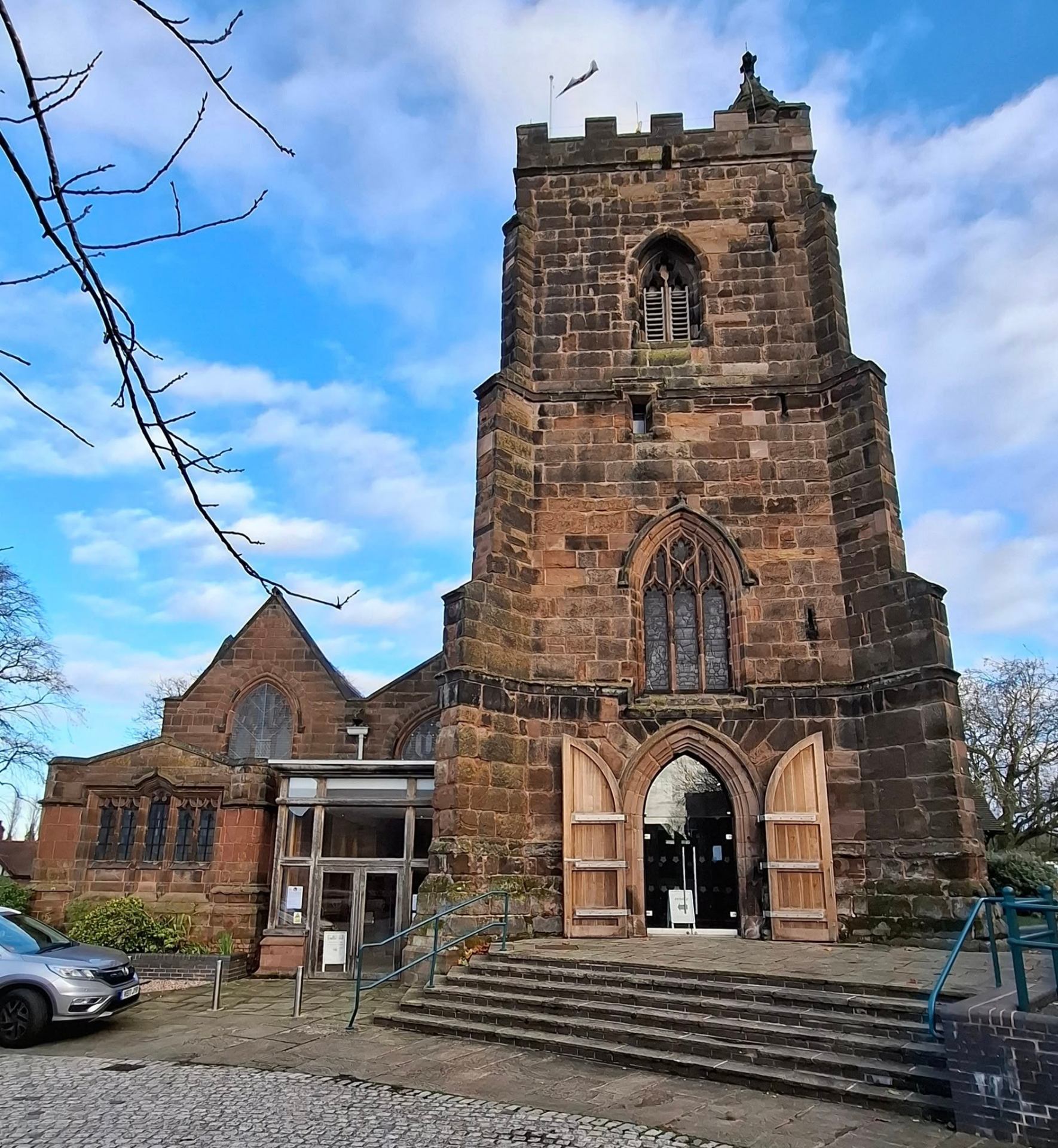 Historic sandstone church tower against a blue sky