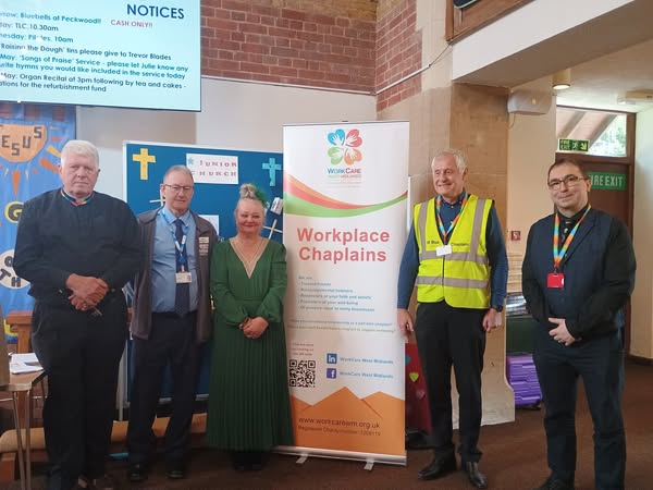 Chaplains standing with the WorkCare banner